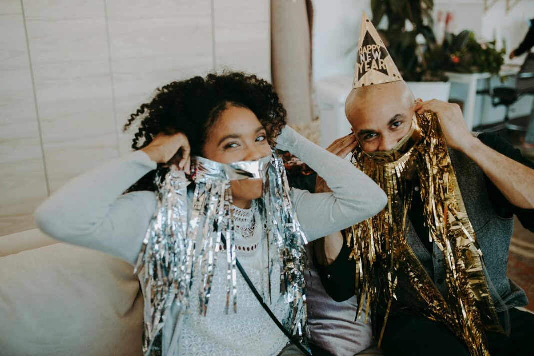 A fun New Year's gathering featuring playful tinsel and party hats indoors.