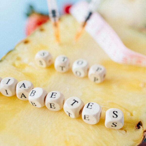 Symbolic image of diabetes prevention message with pineapple and insulin syringes.