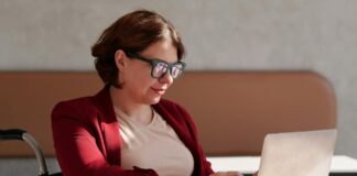 How To Lose 11 Pounds in 28 Days Using Quantum Nutrition Principles Woman in a red blazer working on laptop at café table with coffee and snack.